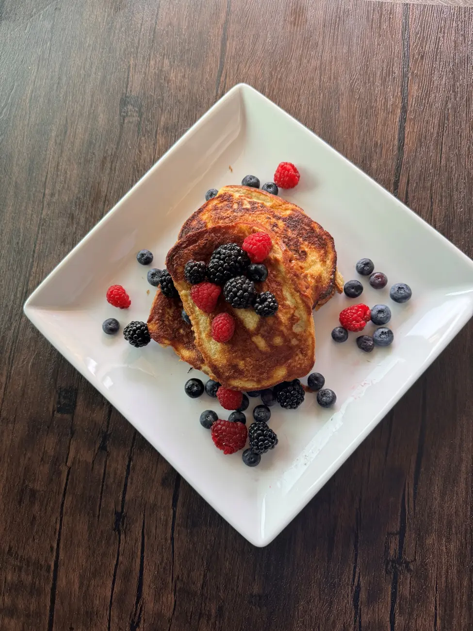 A white plate topped with pancakes and berries.