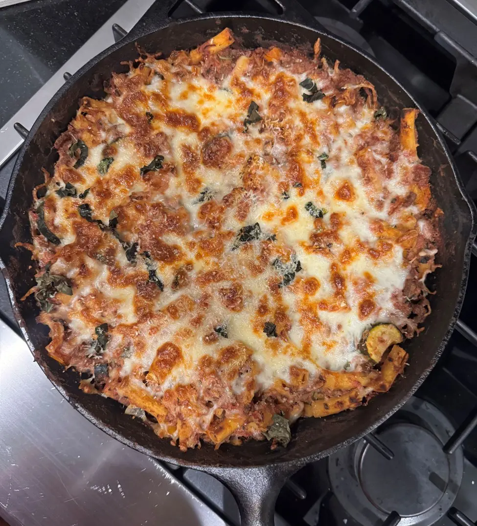 A pan of pizza with cheese and vegetables.