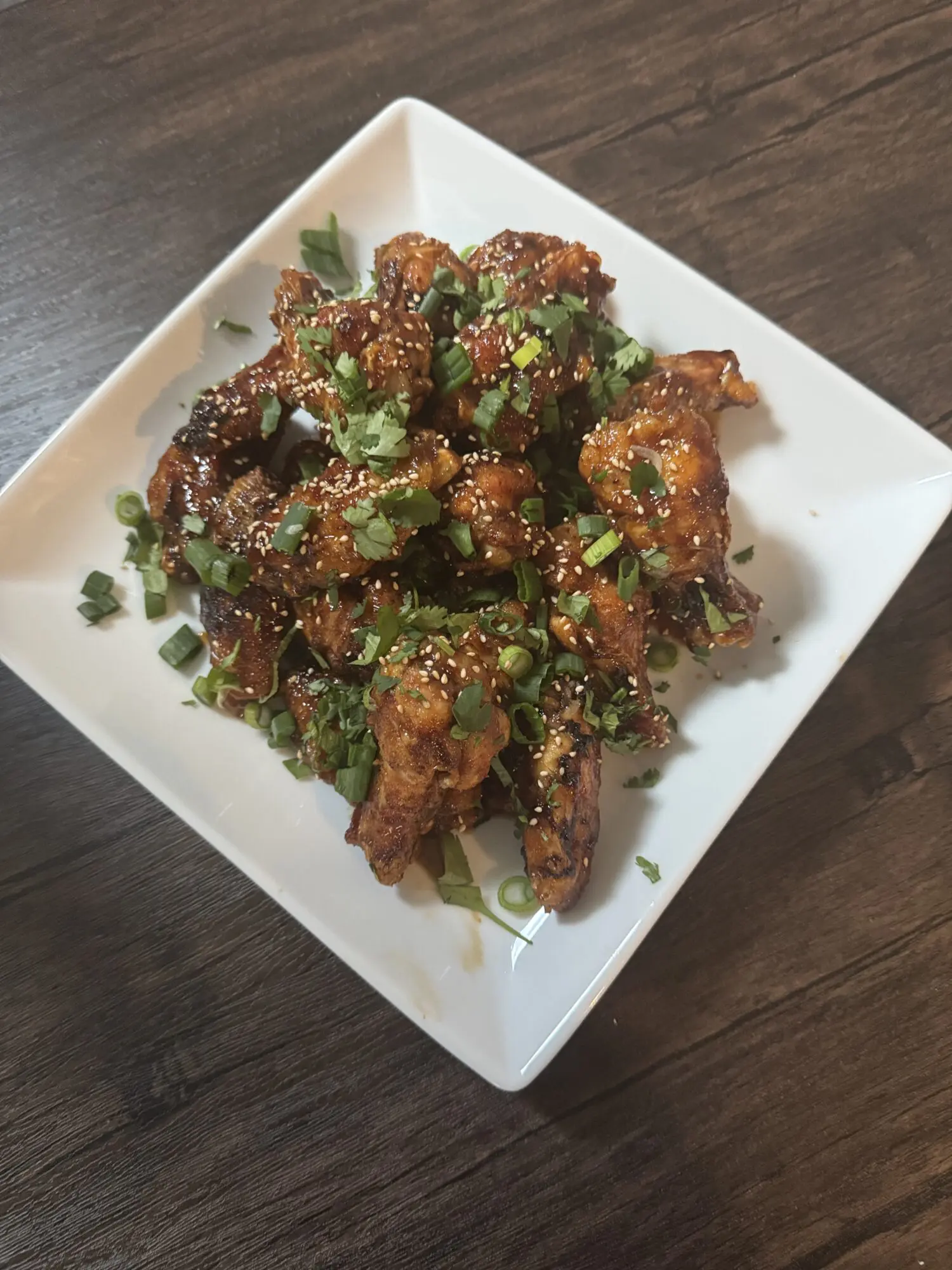 A white plate topped with meat covered in sauce.