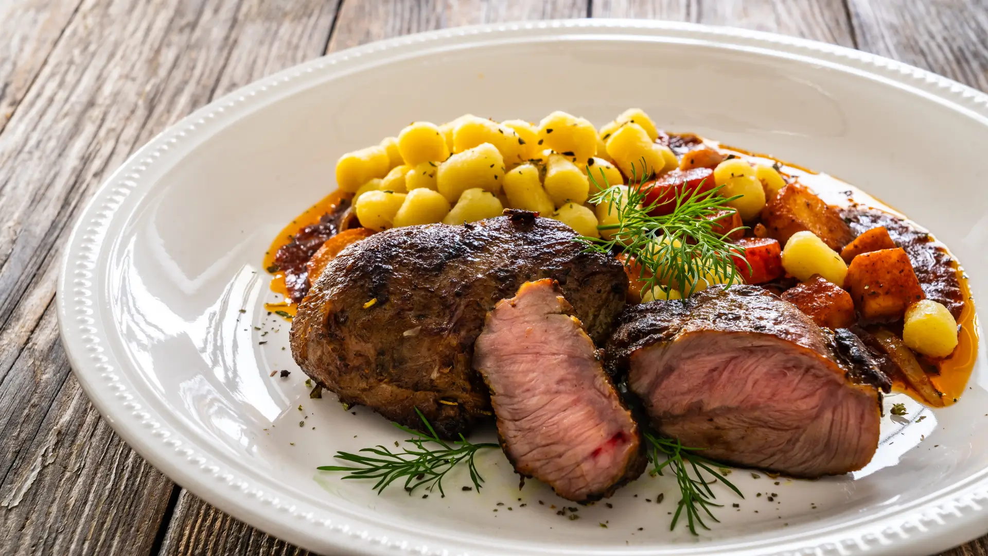 A plate of food with corn and steak on it.